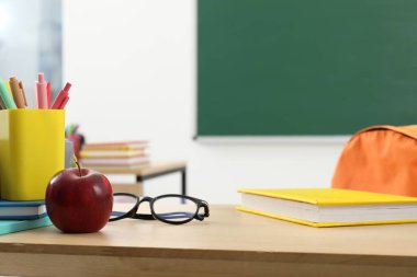 Farklı okul kırtasiyesi, gözlük ve kırmızı elma.