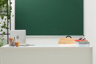 Farklı okul kırtasiyesi, dizüstü bilgisayar, gözlük ve elma.