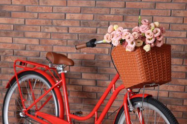 Bisiklet, içinde güzel çiçeklerle dolu bir sepet, duvarın içinde, yakın plan.