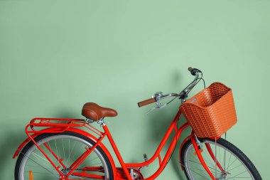 Açık yeşil duvarın yanında sepeti olan kırmızı bisiklet. Metin için boşluk
