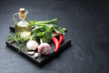 Siyah masa üzerinde farklı taze otlar ve baharatlar, metin için yer