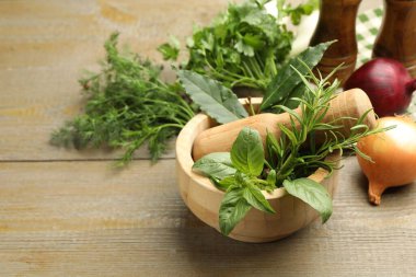 Tahta masadaki havanda farklı aromatik otlar, yakın plan.