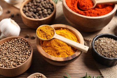 Ahşap masada farklı aromatik baharatlar, yakın plan.