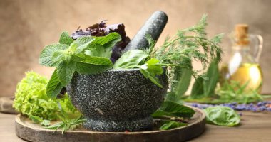 Tahta masada farklı taze otları harca serp, yakın plan.