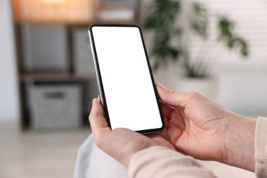 Evde modern akıllı telefon kullanan bir kadın, yakın plan.