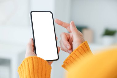 Evde modern akıllı telefon kullanan bir kadın, yakın plan.