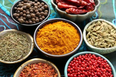 Masanın üzerinde kumaşlı, yakın plan birçok farklı aromatik baharat var.