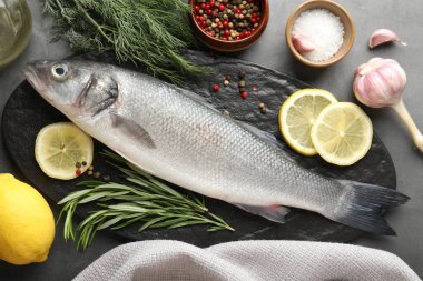 Gri masadaki baharatlı taze çiğ deniz kabuğu, düz. Balık ve deniz ürünleri lezzetleri