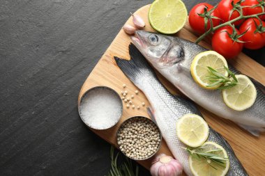 Siyah masadaki baharatlı taze çiğ deniz kabuğu balığı, üst görünüm ve metin için yer. Deniz ürünleri lezzetleri.