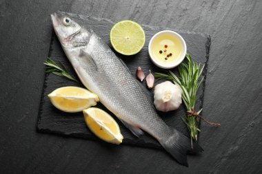 Siyah masadaki baharatlı taze çiğ deniz kabuğu. Balık ve deniz ürünleri lezzetleri