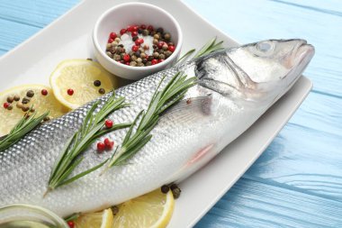 Mavi ahşap masada baharatlı taze çiğ deniz kabuğu, yakın plan. Balık ve deniz ürünleri lezzetleri