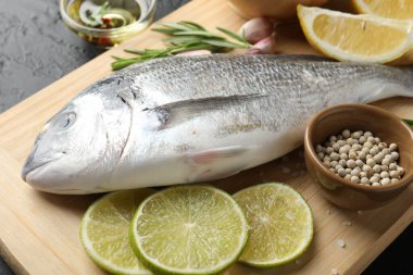 Siyah masada baharatlı taze çiğ dourade, yakın plan. Balık ve deniz ürünleri lezzetleri