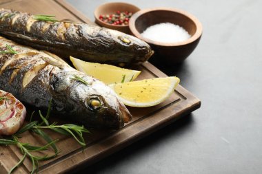 Gri masada biberiye ve limonla servis edilen lezzetli kavrulmuş deniz kabuğu balığı, yakın plan ve yazı için yer. Ev yapımı deniz ürünleri yemeği.