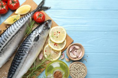 Deniz ürünleri lezzetleri. Taze çiğ uskumrular ve baharatlar açık mavi ahşap masada, düz yerde. Metin için boşluk