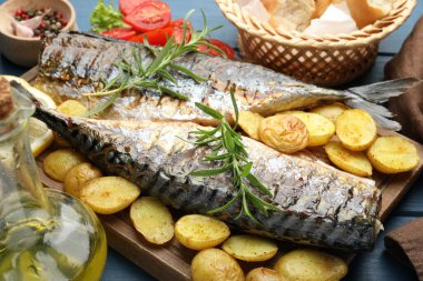 Sofrada baharat ve sebzelerle servis edilen kızarmış uskumrular, yakın plan. Ev yapımı deniz ürünleri yemeği.