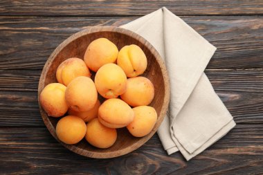 Tahta masadaki kasede taze kayısılar, üst manzara.