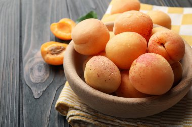 Tahta masadaki kasede taze ıslak kayısılar, yakın plan.