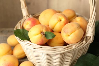 Hasır sepetteki taze kayısılar masada, yakın plan.