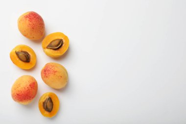 Beyaz arka planda taze olgun kayısılar, düz uzanış. Metin için boşluk