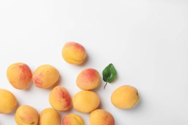 Taze kayısılar ve beyaz arka planda yeşil bir yaprak. Metin için boşluk