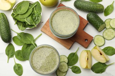 Lezzetli meyve püresi ve ıspanak yaprakları beyaz mermer masada, düz yerde.