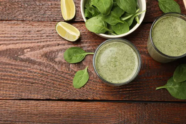 Lezzetli ıspanaklı smoothie ve ahşap masa üzerindeki malzemeler, düz yatak. Metin için boşluk