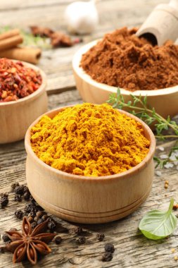 Ahşap masada farklı aromatik baharatlar, yakın plan.