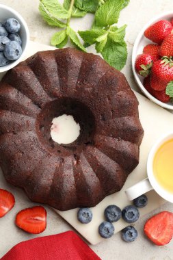 Lezzetli çikolatalı kek, çay ve böğürtlen ışık masasında.