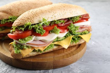 Gri desenli masada jambonlu, peynirli ve sebzeli lezzetli baget sandviçler.