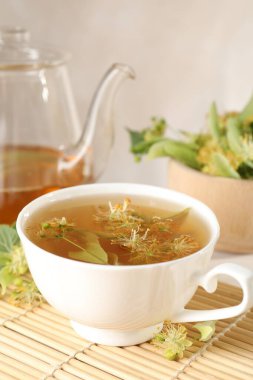 Taze ıhlamur çayı, çaydanlık ve çiçekler masada, yakın plan.