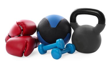 İlaç topu, kettlebell, dambıl ve boks eldivenleri beyaza izole edilmiş.
