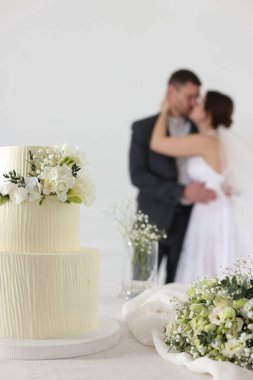 Mutlu evli çift içeride, düğün pastasına ve masadaki bukete odaklan.