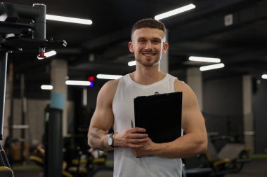 Spor merkezinde panosu olan kişisel antrenör.