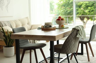 Ahşap masa, sandalyeler, kanepe ve dekorasyon yemek odasında. İç tasarım