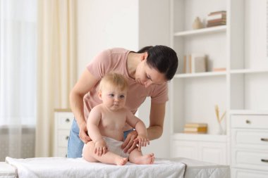 Anne evde bebeğinin bezini değiştiriyor.