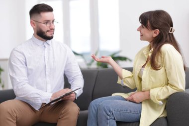 Ofisteki koltukta hastayla çalışan profesyonel psikolog.