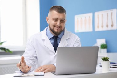 Klinikte bilgisayarla online danışmanlık yapan bir doktor