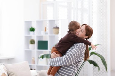 Mutlu anne evde oğluna sarılıyor. Metin için boşluk