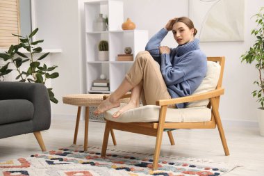 Evdeki rahat koltukta dinlenen güzel kadın.