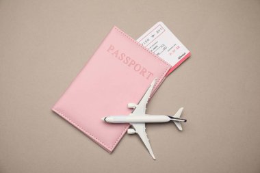 Uçak modeli, pasaport ve bej arka planda uçuş bileti, düz konum