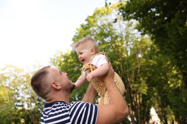 Baba yeni doğmuş bebeğiyle dışarıda eğleniyor. Babalar Günün kutlu olsun.