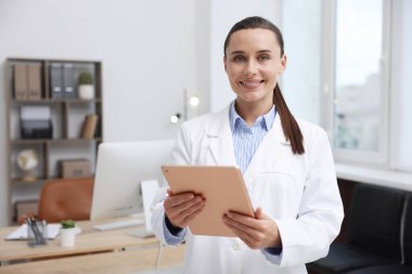 Doktor klinikte tablet kullanıyor, mesaj için yer var. Online tıbbi danışmanlık