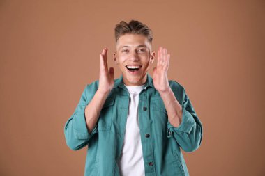 Kahverengi arka planda şaşırmış bir adamın portresi