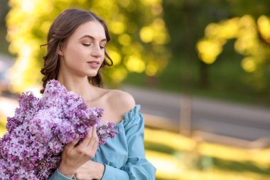 Sabahları elinde bir buket leylak çiçeğiyle gülümseyen kadın. Metin için boşluk