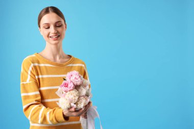 Açık mavi arka planda şakayık demeti olan güzel bir kadın, mesaj için yer var.