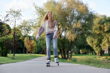 Parkta paten kayan mutlu genç kadın.