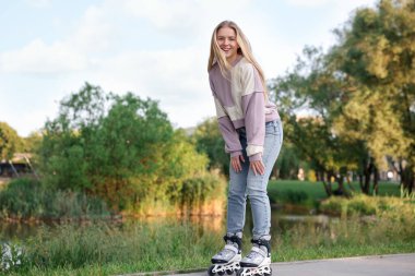 Parkta paten kayan mutlu genç kadın.