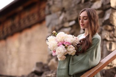 Şehir caddesinde bir buket güzel şakayığı olan çekici bir kadın. Metin için boşluk