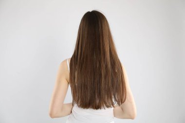 Uzun saçlı, arka planda açık renk saçlı bir kadın.