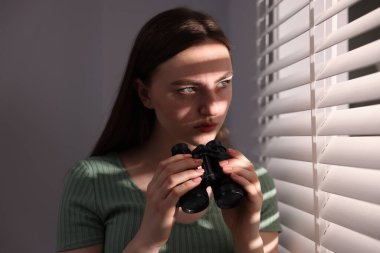 Paranoya işte. Pencerenin yanında dürbünü olan endişeli kadın.